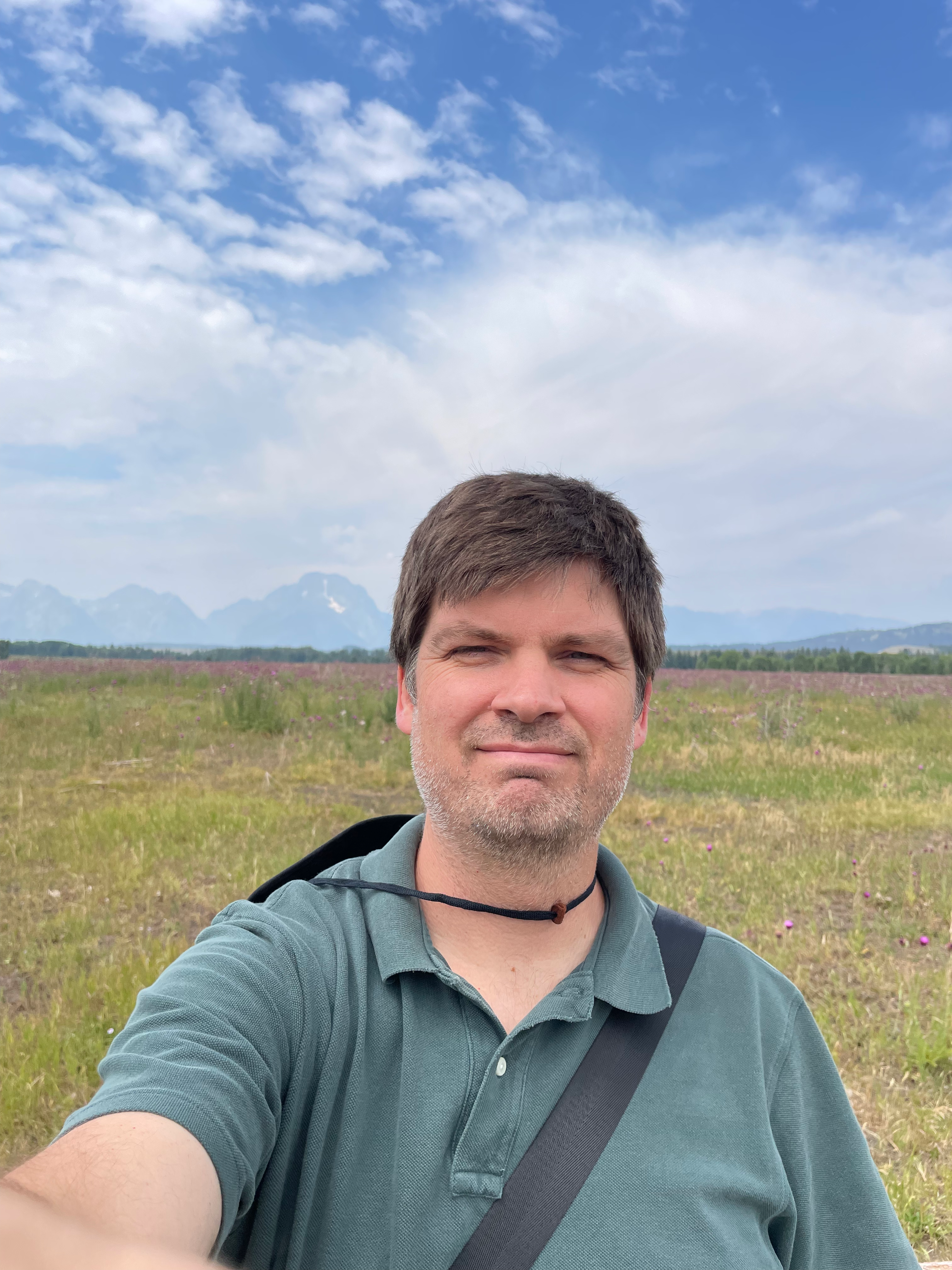 Photograph of Justin Dealy in front of the Grand Tetons